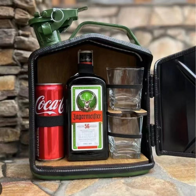 Minibar compacto de bidon verde de 5 L abierto con Coca-Cola, Jagermeister y vasos sobre piedra