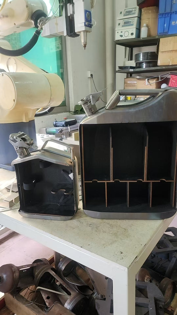 Black jerry can mini bar open in workshop showing interior divider assembly