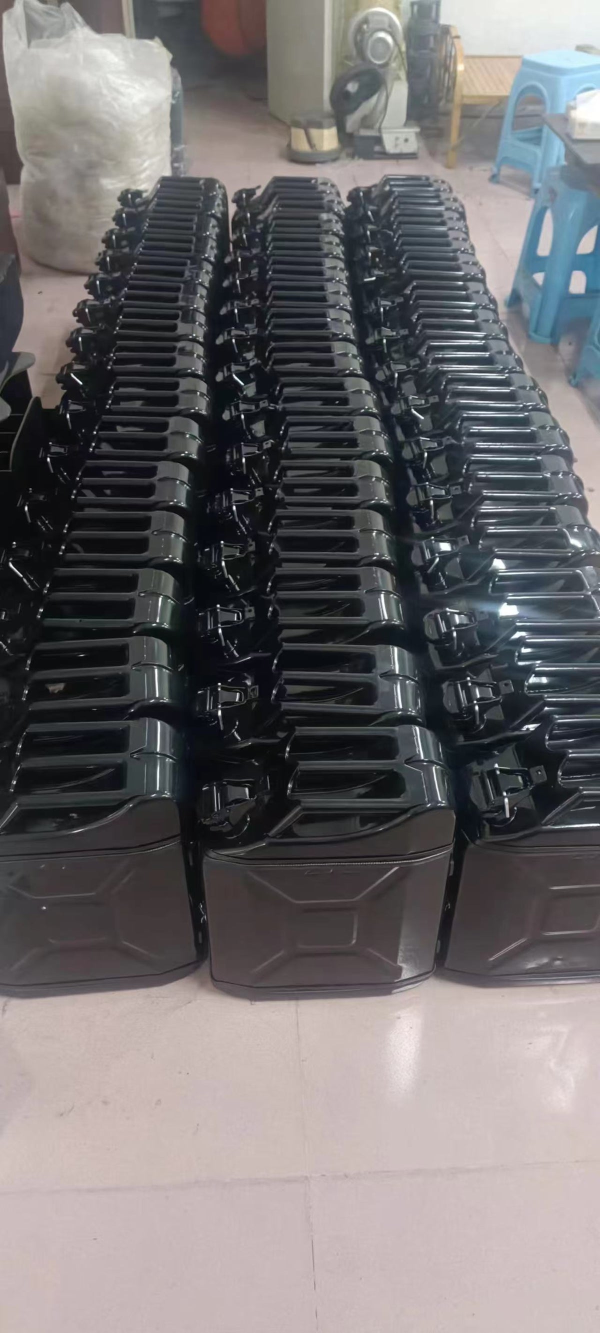 Batch of glossy black jerry can mini bar shells lined up in workshop